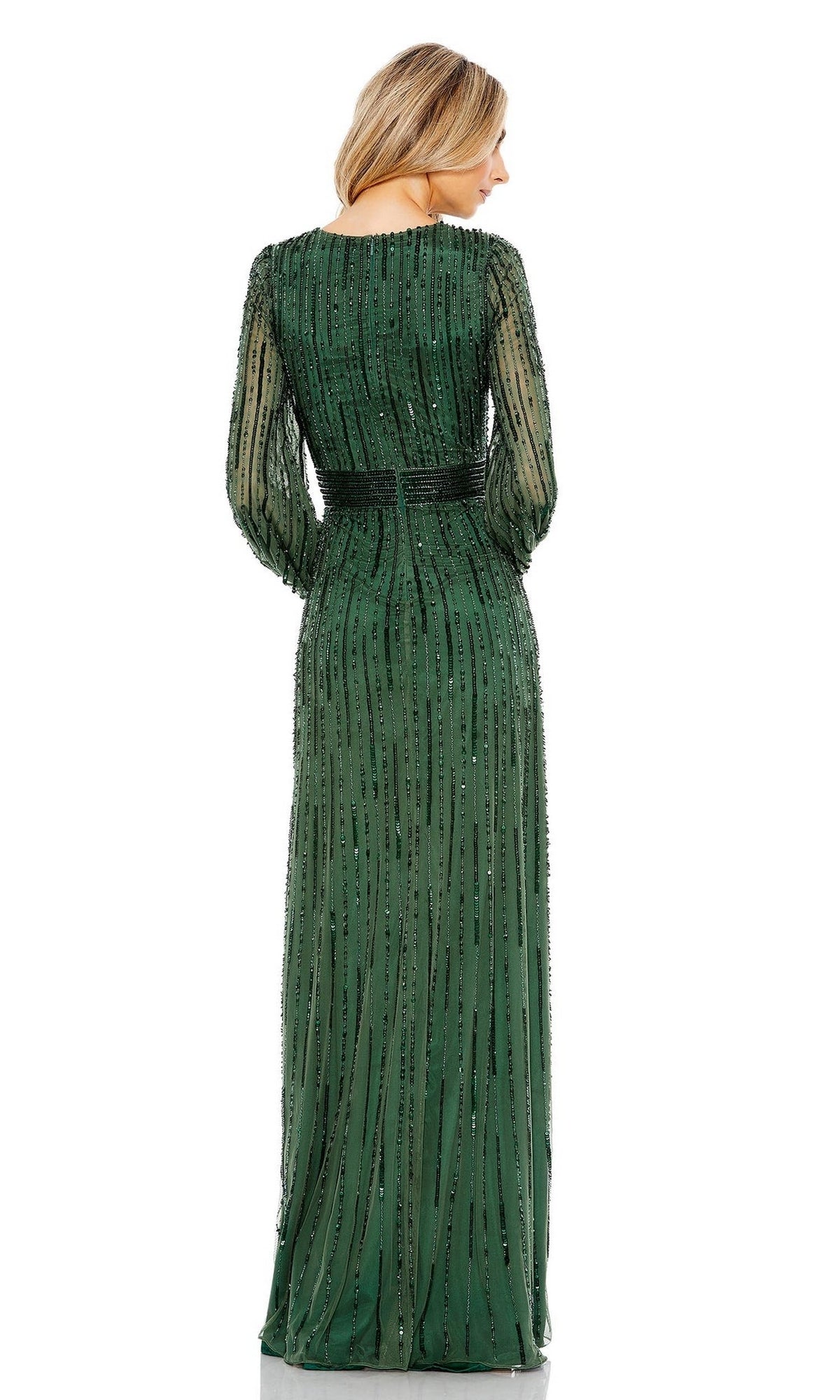 A woman stands facing away, wearing the Long Formal Dress 5718 by Mac Duggal—a floor-length green gown with black bead embellishments, a fitted beaded waist, and long sleeves.